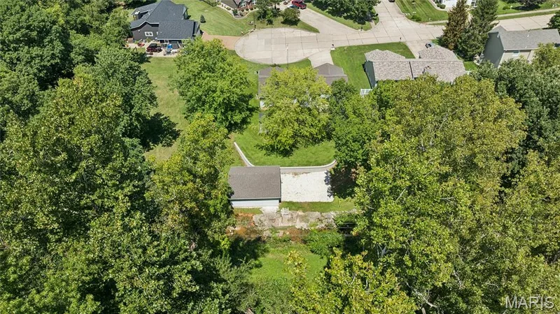 See it from above: a private, tree-lined lot with a detached shop tucked at the back, space you simply won't find on a typical subdivision lot. — 416 Loiselaine Drive, O'Fallon, MO 63366