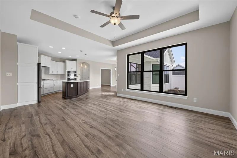 Living Room with Luxury Vinyl Plank Flooring, Tray Ceiling and Black on Black Low E Windows — 149 Haven Ridge Court, Dardenne Prairie, MO 63368