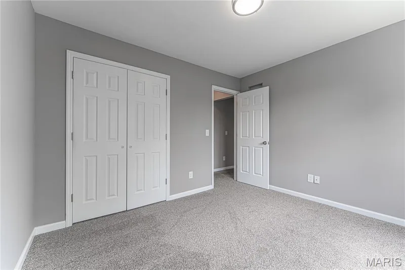 Neutral gray wall paint, textured gray carpeting, white trim, white paneled doors, and a ceiling-mounted light fixture — 1721 Summergate Court, St Charles, MO 63303