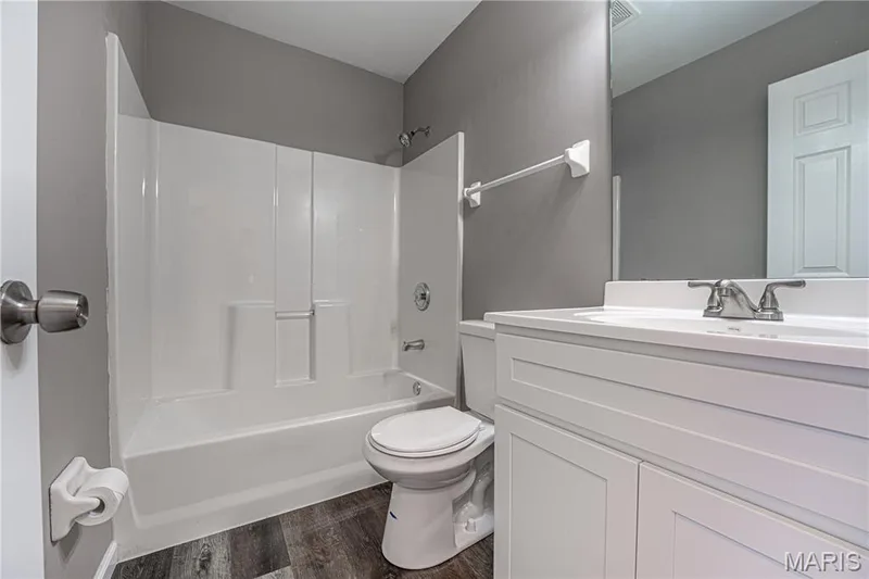 White vanity with integrated sink, chrome faucet, and mirrored wall — 1721 Summergate Court, St Charles, MO 63303