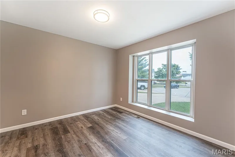 Neutral wall color, wood-finish flooring, white trim, and a flush-mount ceiling light — 1721 Summergate Court, St Charles, MO 63303