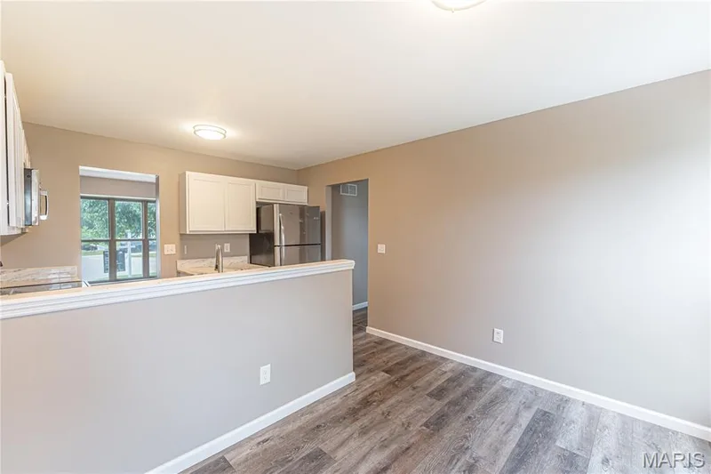 Modern kitchen featuring white cabinetry, stainless steel appliances, and a pass-through window — 1721 Summergate Court, St Charles, MO 63303