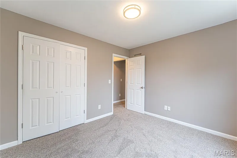 Neutral wall paint, plush carpet flooring, bi-fold closet doors, and a ceiling-mounted light fixture — 1721 Summergate Court, St Charles, MO 63303