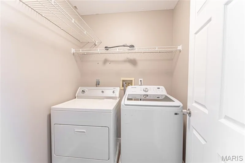 Laundry area featuring white appliances and wall-mounted wire shelving — 1721 Summergate Court, St Charles, MO 63303