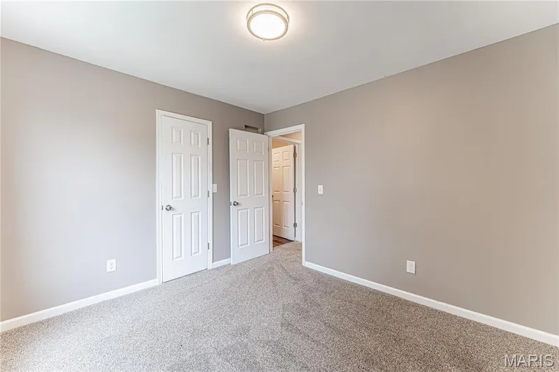 Neutral-toned walls, plush carpeting, white interior doors, and a ceiling-mounted light fixture — 1721 Summergate Court, St Charles, MO 63303