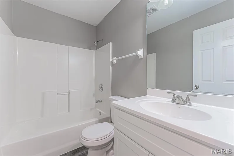 White vanity with integrated sink, brushed nickel faucet, and frameless wall mirror — 1721 Summergate Court, St Charles, MO 63303