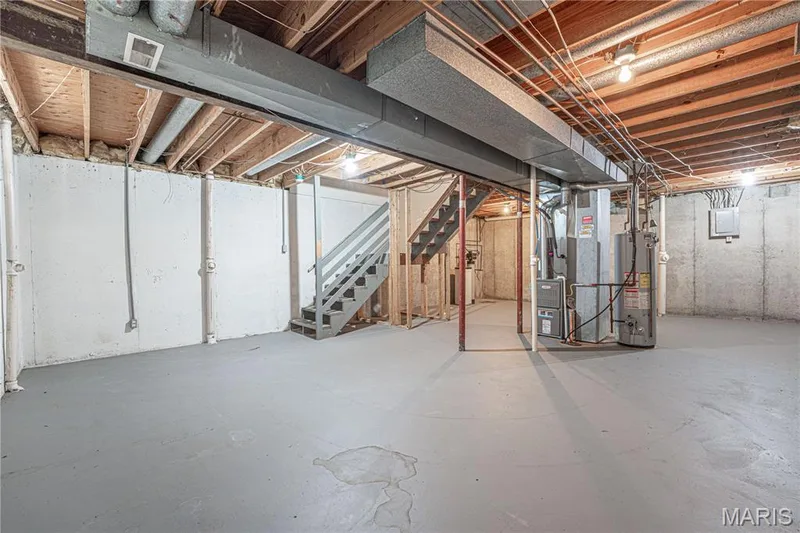 Unfinished basement featuring concrete walls and flooring, exposed ceiling joists, and a utility area with water heater and furnace — 1721 Summergate Court, St Charles, MO 63303