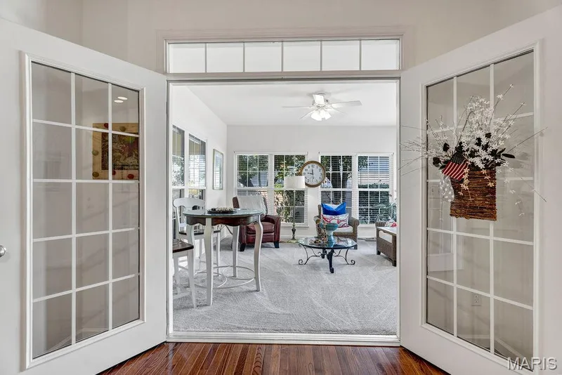 Double door opening into the sunroom addition with a decorative transom-style window atop. — 781 Queens Court Place, St Peters, MO 63376