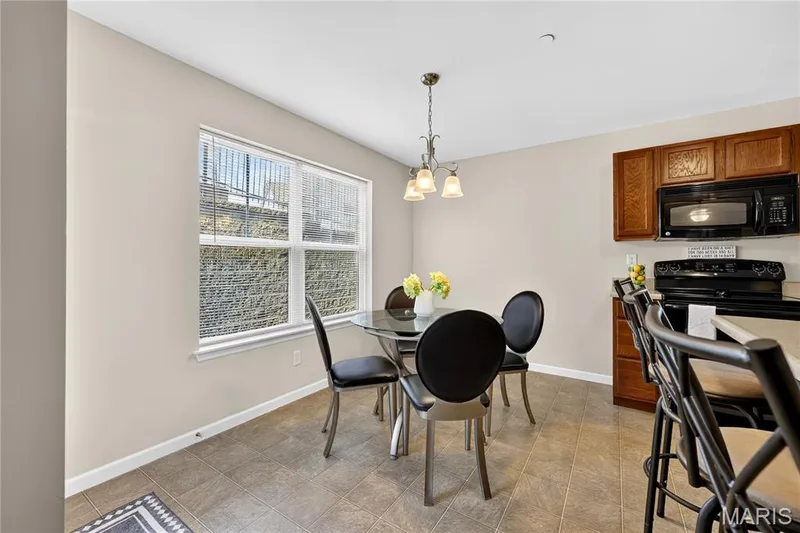 Kitchen with wood cabinetry, black appliances, and a tiled floor — 313 Bramblett Hills, O'Fallon, MO 63366