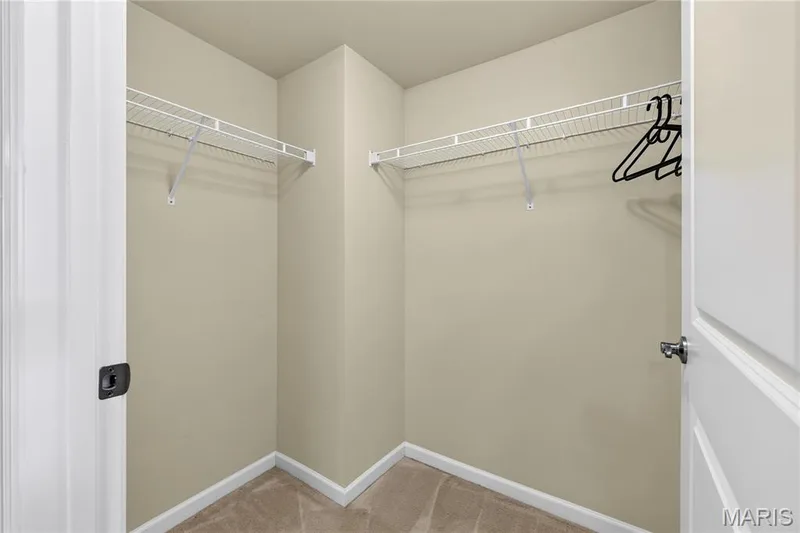 Carpeted walk-in closet with wire shelving and clothes rods — 313 Bramblett Hills, O'Fallon, MO 63366