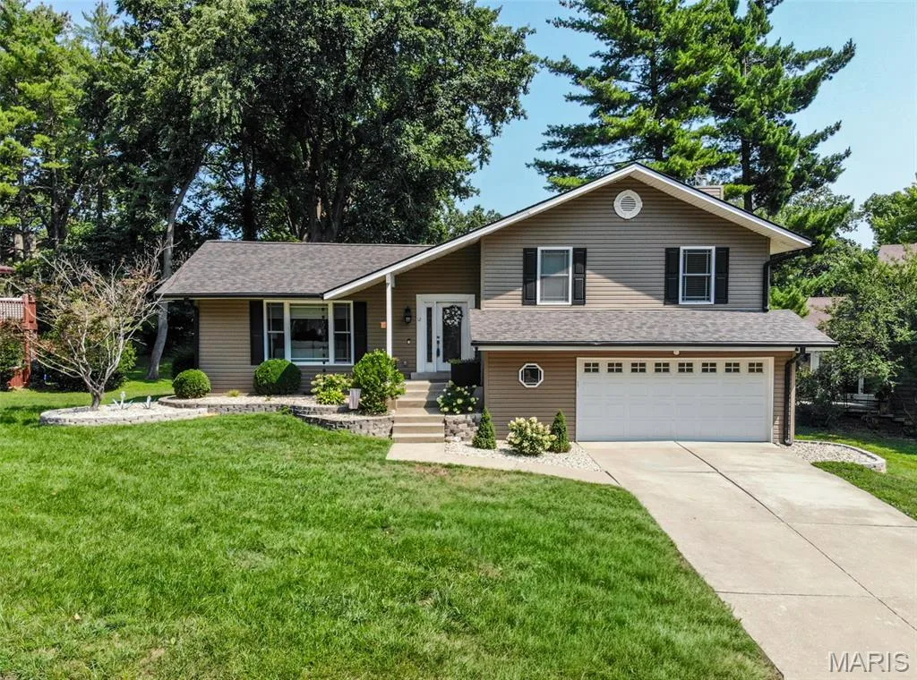 Multi-level residence featuring two-car garage, covered front porch and beautiful landscaping — 12 Pyrenees Drive, Lake St. Louis, MO 63367
