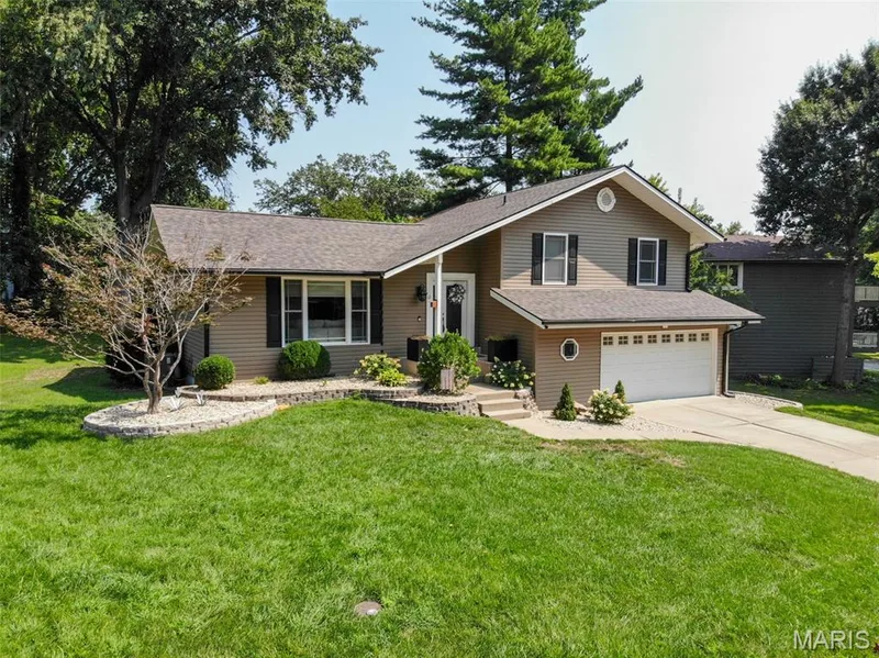 Multi-level residence featuring two-car garage, covered front porch and beautiful landscaping — 12 Pyrenees Drive, Lake St. Louis, MO 63367
