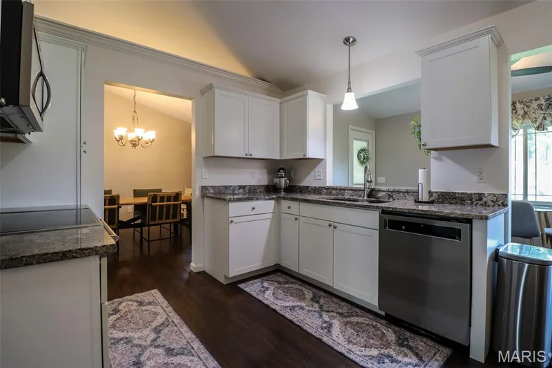 Kitchen featuring white custom cabinetry, stainless steel appliances, and granite counters — 12 Pyrenees Drive, Lake St. Louis, MO 63367