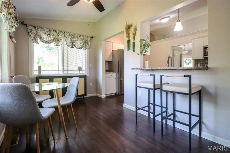 Dining area off the kitchen featuring a ceiling fan and breakfast bar — 12 Pyrenees Drive, Lake St. Louis, MO 63367