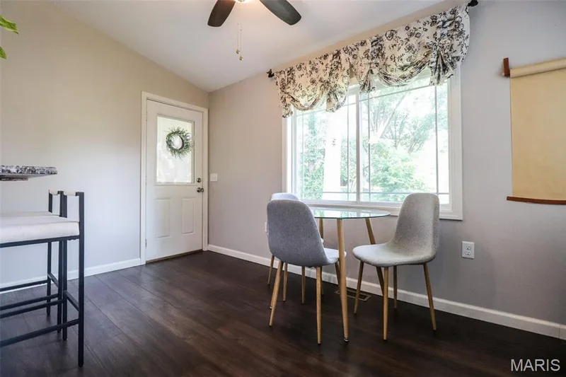 Dining area off the kitchen featuring a ceiling fan and breakfast bar leading to the covered deck — 12 Pyrenees Drive, Lake St. Louis, MO 63367