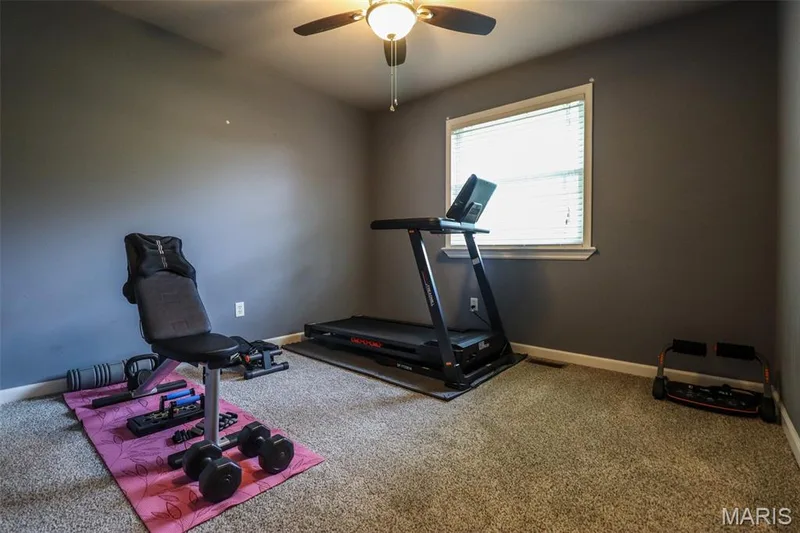 Third bedroom used as an exercise room features ceiling fan and window with blinds — 12 Pyrenees Drive, Lake St. Louis, MO 63367