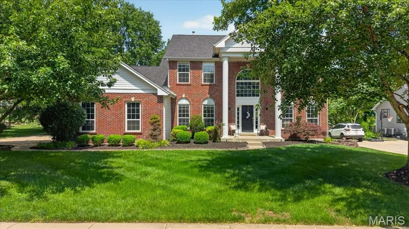 Traditional brick exterior featuring a prominent two-story entry with white columns and a grand arched window — 17821 Wilderness Cliff Court, Wildwood, MO 63005