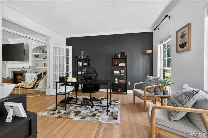 Private office space featuring French doors, wood-finish flooring, and a contrasting accent wall — 17821 Wilderness Cliff Court, Wildwood, MO 63005
