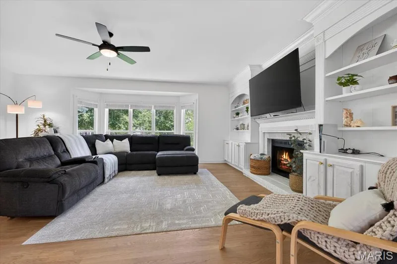 Living area featuring wood-finish flooring and a bay window — 17821 Wilderness Cliff Court, Wildwood, MO 63005