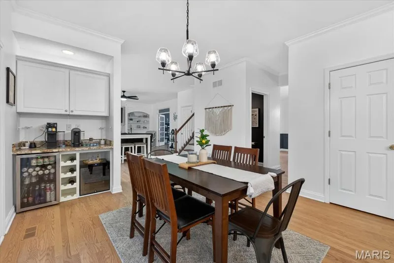 Bright dining area featuring wood-finish flooring and a contemporary chandelier — 17821 Wilderness Cliff Court, Wildwood, MO 63005