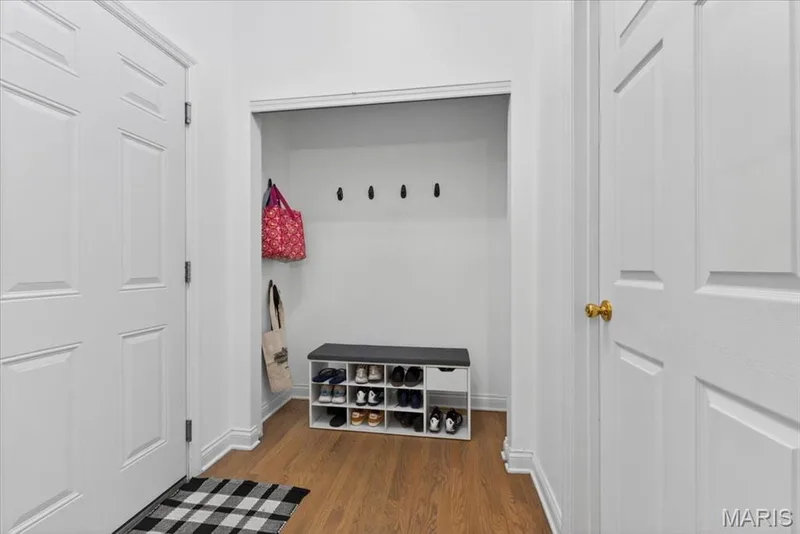 Entryway featuring wood-finish flooring, white paneled doors, and a recessed alcove — 17821 Wilderness Cliff Court, Wildwood, MO 63005
