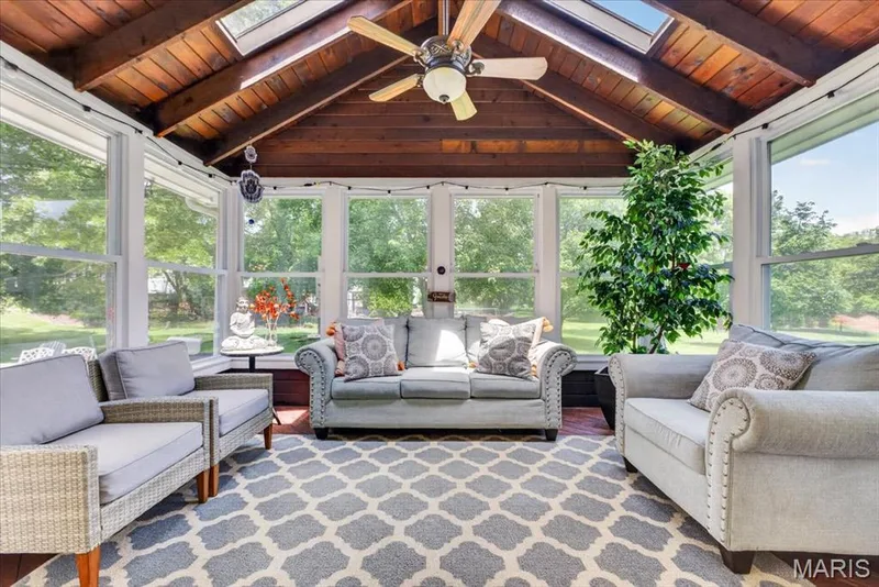 Sunroom featuring a vaulted wood-finish ceiling, exposed beams, and multiple skylights — 17821 Wilderness Cliff Court, Wildwood, MO 63005