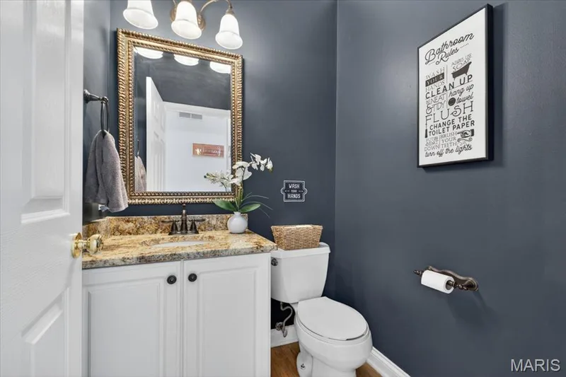 Bathroom featuring a white vanity with a granite countertop, undermount sink, and matte black faucet — 17821 Wilderness Cliff Court, Wildwood, MO 63005