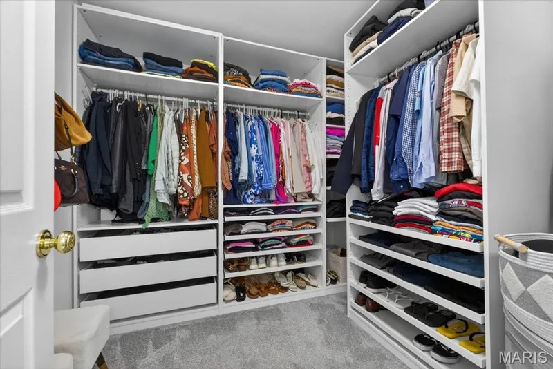 Custom closet system featuring multiple hanging rods, integrated shelving, and pull-out drawers — 17821 Wilderness Cliff Court, Wildwood, MO 63005