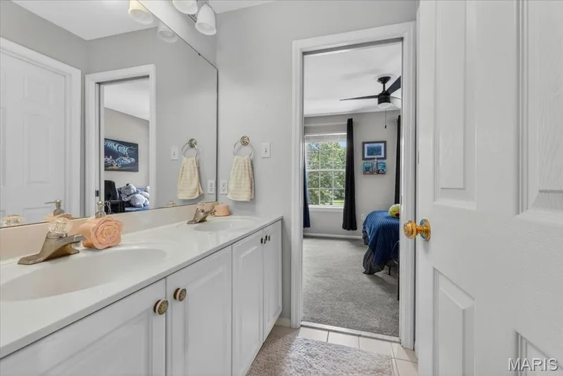 Double vanity with white cabinetry and integrated sinks — 17821 Wilderness Cliff Court, Wildwood, MO 63005