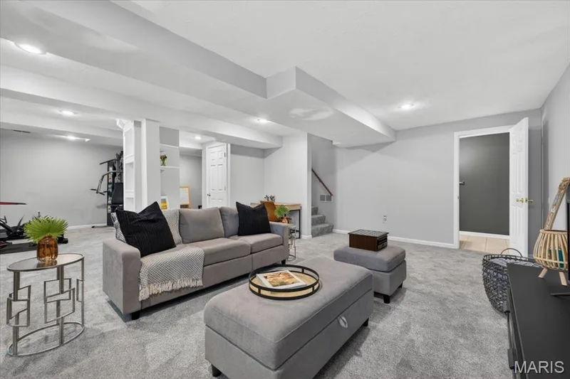 Spacious lower level featuring light gray walls, recessed lighting, carpeted flooring, and a built-in shelving unit — 17821 Wilderness Cliff Court, Wildwood, MO 63005