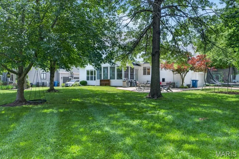 Spacious rear lawn with mature trees and a rear patio — 17821 Wilderness Cliff Court, Wildwood, MO 63005