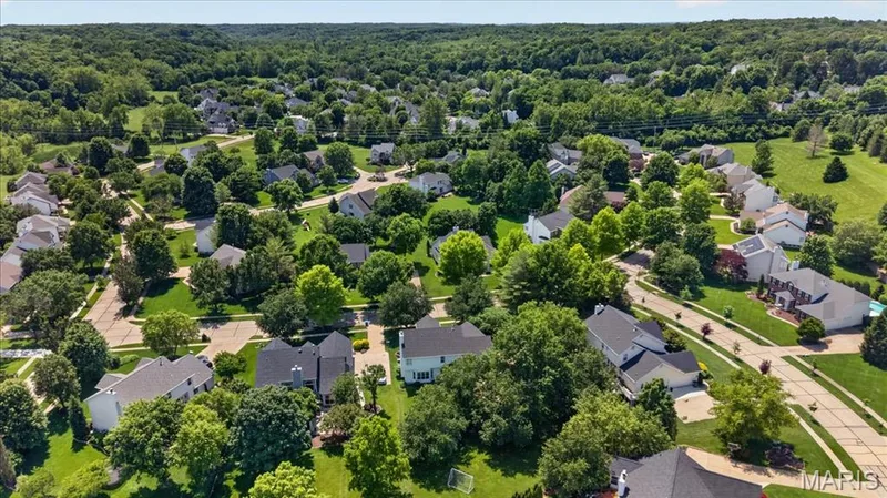 Expansive residential area with numerous houses featuring diverse architectural styles, surrounded by mature trees and verdant landscaping — 17821 Wilderness Cliff Court, Wildwood, MO 63005