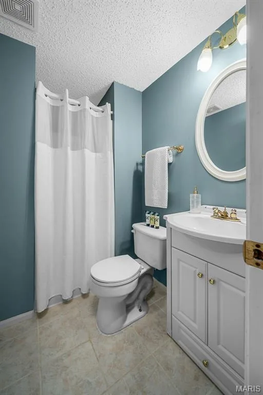 White vanity with integrated sink, gold-toned hardware, and an oval mirror — 120 Bromley Court, O'Fallon, MO 63368