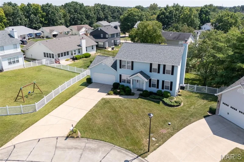 Two-story residence with a light blue exterior, attached garage, and a long driveway — 120 Bromley Court, O'Fallon, MO 63368
