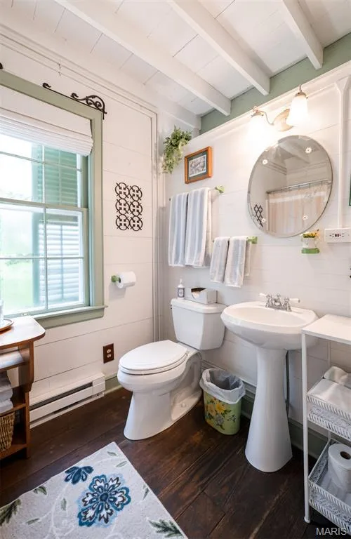 Wood-finish flooring, white shiplap walls, exposed ceiling beams, a pedestal sink, and a window with interior shades — 215 Jackson Street, Augusta, MO 63332