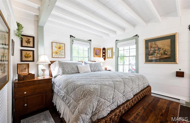 Exposed ceiling beams, white shiplap walls, wood-finish flooring, and multiple windows with trim — 215 Jackson Street, Augusta, MO 63332