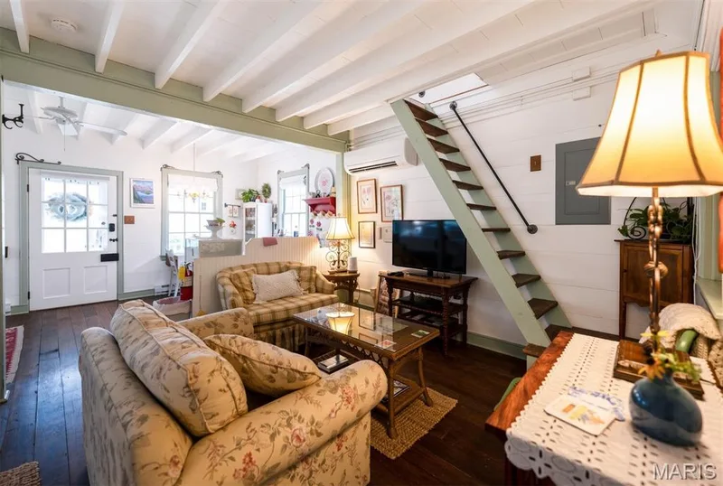 Exposed ceiling beams, rich wood flooring, and a built-in staircase with a handrail — 215 Jackson Street, Augusta, MO 63332