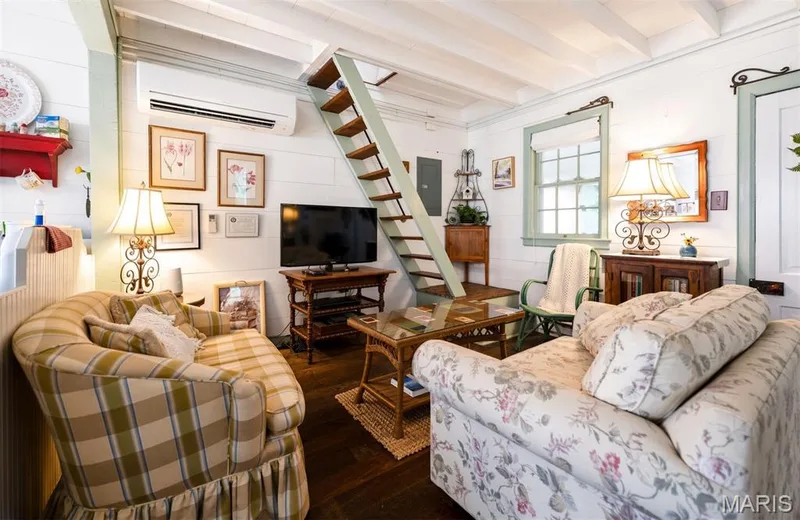 Exposed ceiling beams, wood-finish flooring, interior shiplap walls, window with light-colored trim, and built-in ladder access — 215 Jackson Street, Augusta, MO 63332