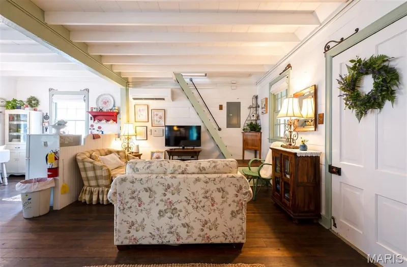 Exposed ceiling beams, wood-finish flooring, white paneling, and an open concept layout — 215 Jackson Street, Augusta, MO 63332