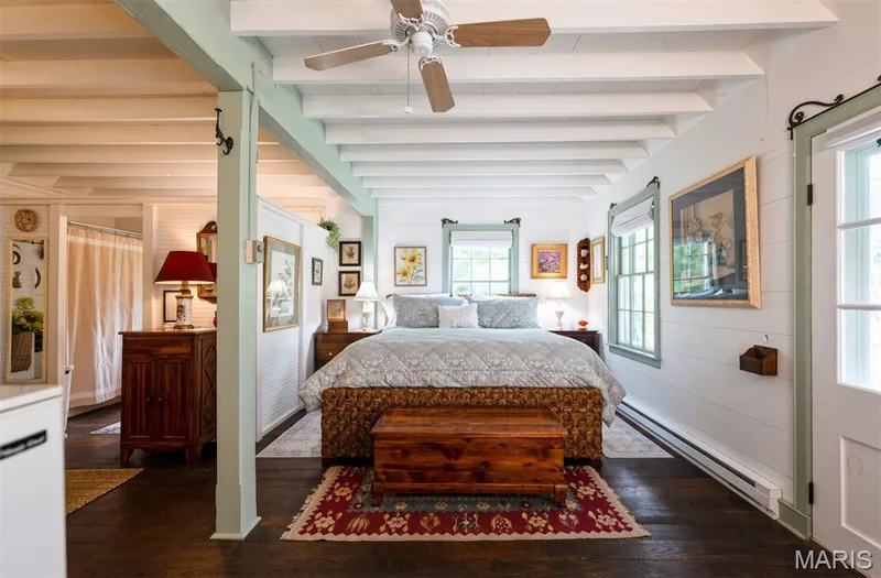 Exposed ceiling beams, wood-finish flooring, multiple windows, and a ceiling fan — 215 Jackson Street, Augusta, MO 63332