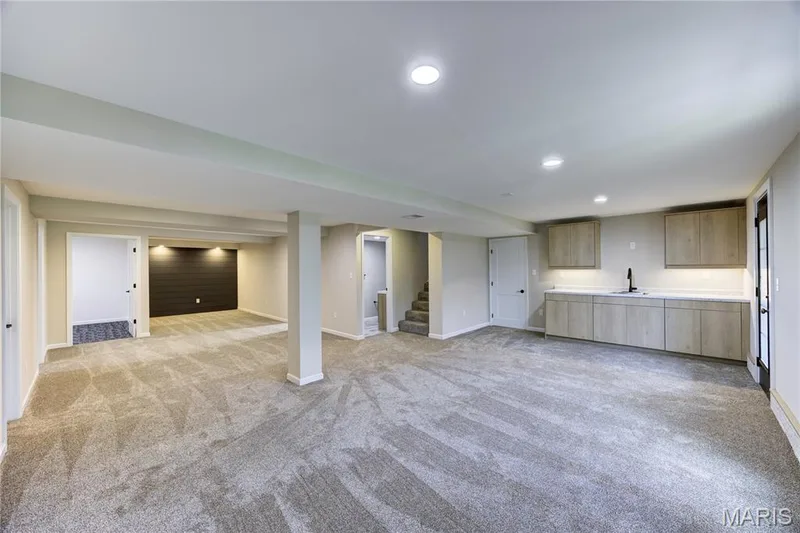 View of rec room looking towards flex room, storage area, media nook and wet bar. — 9 Carriage Way E, St Peters, MO 63376