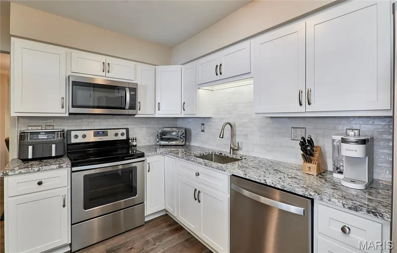 Bright white kitchen with newer granite counter tops and backsplash. — 16463 Cobbleskille Drive, Chesterfield, MO 63017