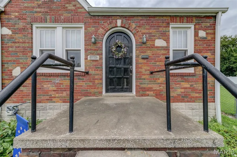 A small front porch leads you to the arched front doorway. — 2009 N 3rd Street, St Charles, MO 63301