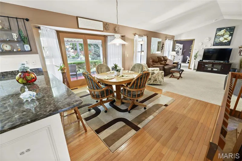 Hardwood flooring transitions to carpeted living area with vaulted ceiling — 38 Fawn Valley Circle, St Peters, MO 63376