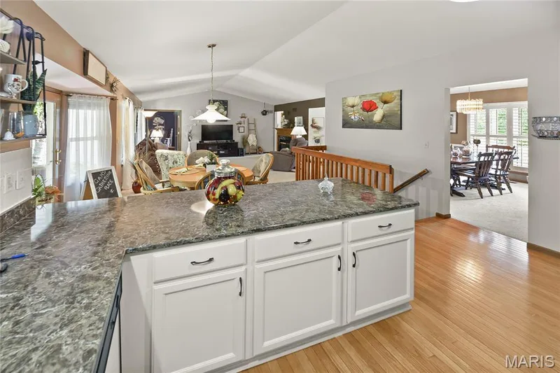 Kitchen island featuring a patterned countertop and white cabinetry — 38 Fawn Valley Circle, St Peters, MO 63376