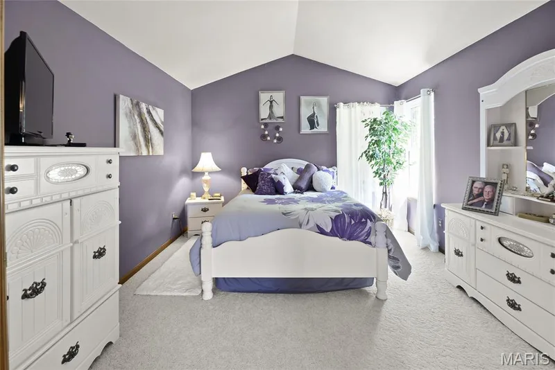 Vaulted ceiling with light-toned walls, light-toned carpet flooring, and an exterior door with a window — 38 Fawn Valley Circle, St Peters, MO 63376