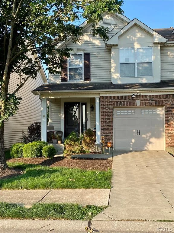 Two-story colonial with brick and siding exterior, front-load garage, concrete driveway, and mature landscaping — 3231 Cog Wheel Station, St Charles, MO 63301