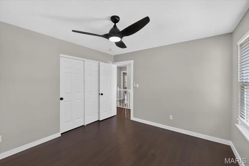 Wood-finish flooring with white trim and a ceiling fan with integrated lighting — 53 Lions Head Court, O'Fallon, MO 63368