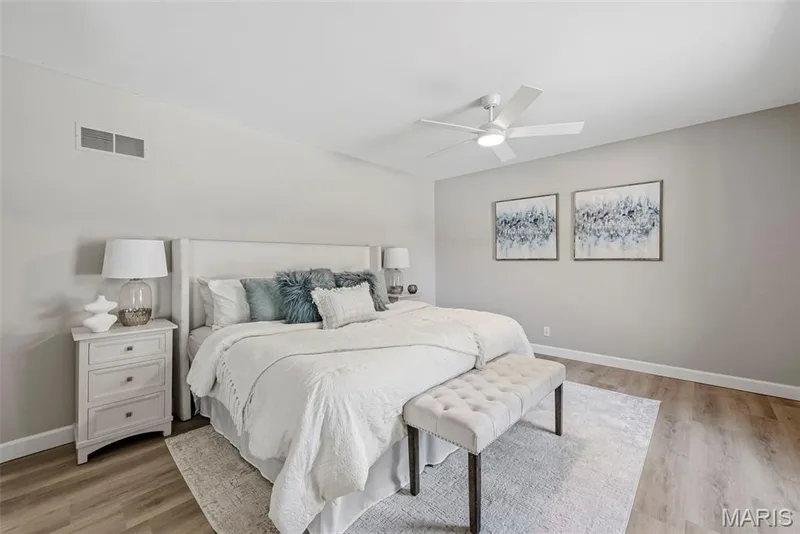 Professionally painted main level primary suite features LVP flooring, ceiling fan with light, en suite bath, and convenient washer and dryer hookups. — 3034 Willow Wood Drive, St Charles, MO 63303