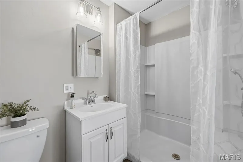 Main level en suite bath features LVP flooring, adult height vanity, and a step in shower with built in bench. — 3034 Willow Wood Drive, St Charles, MO 63303